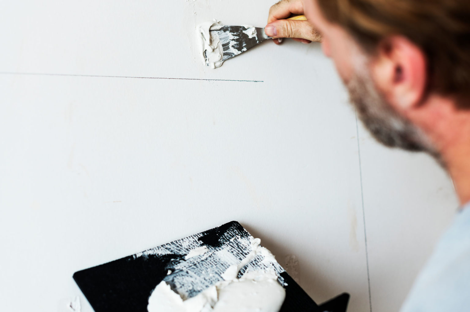 Decorator filling holes in plasterboard